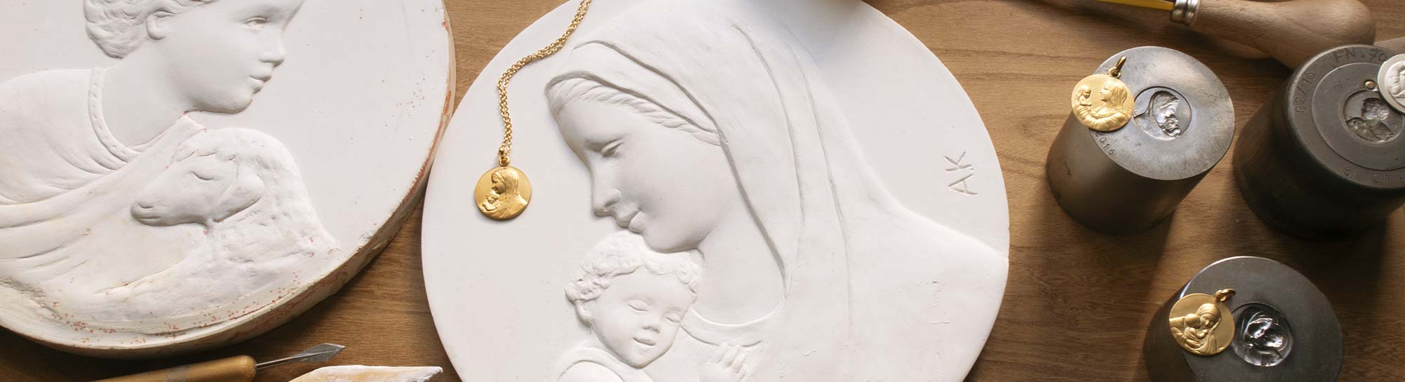 Chaîne de fabrication d'une médaille de baptême, de gauche à droite croquis, plastiline, plâtre, matrices et médaille de baptême en or