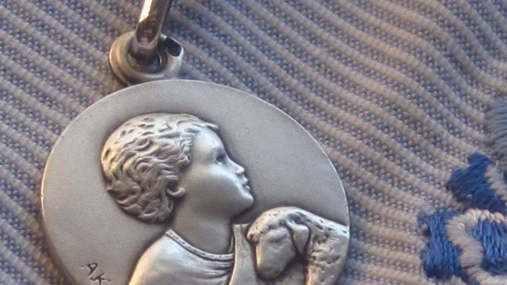 médaille de baptême en argent sur fond en tissus