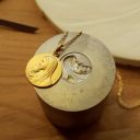 Miniature médaille de baptême notre dame des petits enfants avec chaine maille forçat posée sur une matrice de frappe